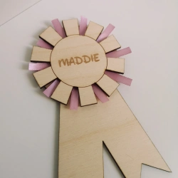 Rosette i tr med navn til hestepiger